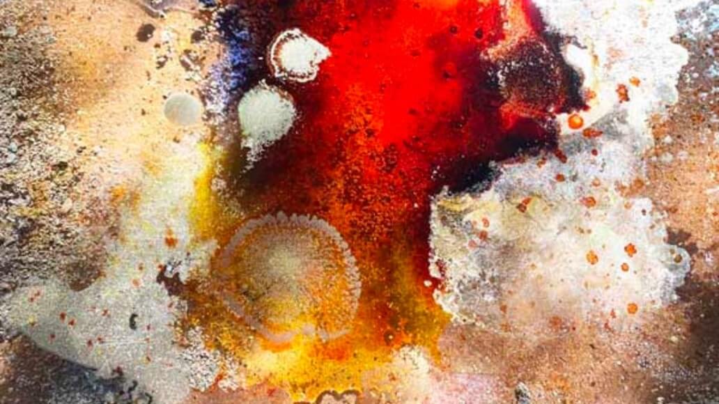 An abstract painting with splashes of red, white, and orange on a textured, earthy background.