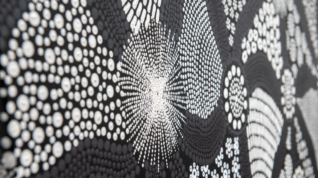 Close-up of an abstract black and white dot pattern resembling a circular, radiating design.