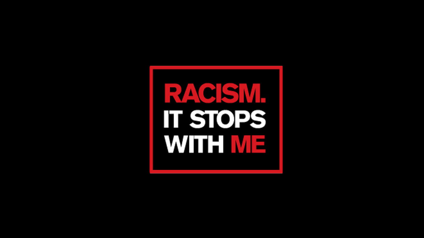 A black background with the text "Racism. It stops with me" in red and white inside a red-bordered rectangle.