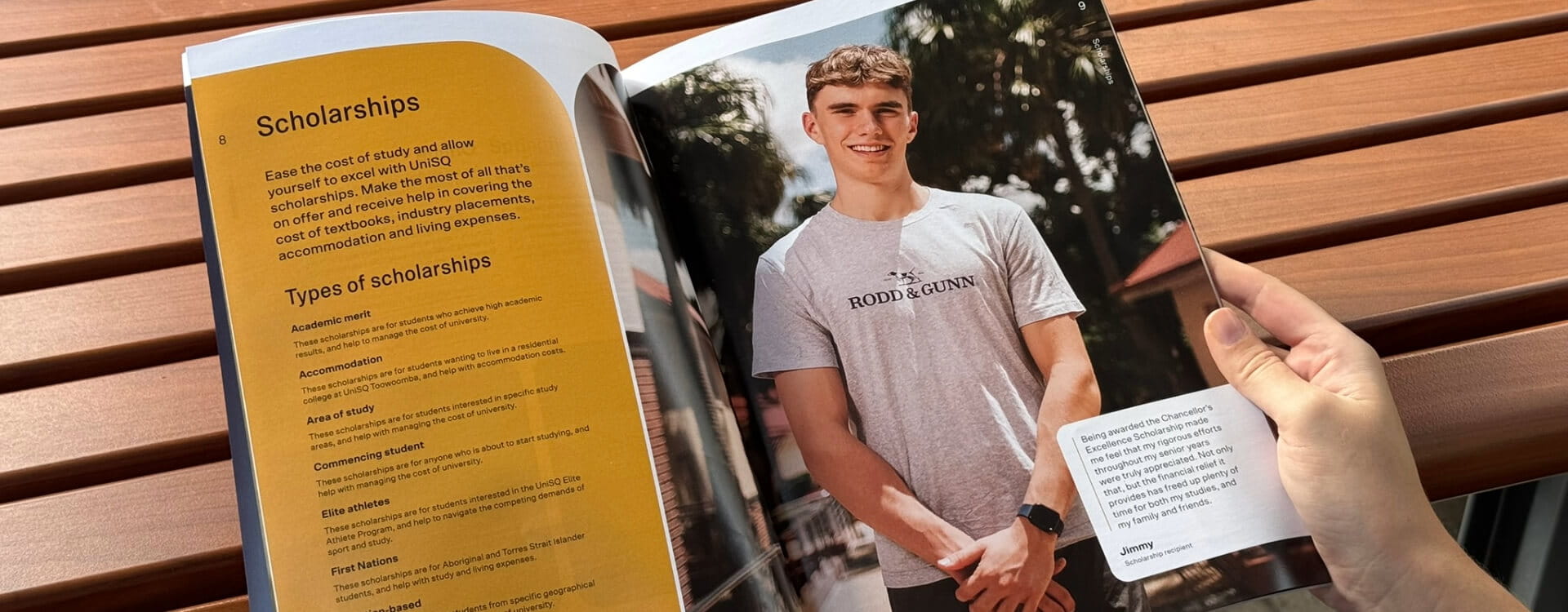 Person holding a magazine open to a page featuring scholarship information on the left and a photo of a smiling young man in a t-shirt on the right.