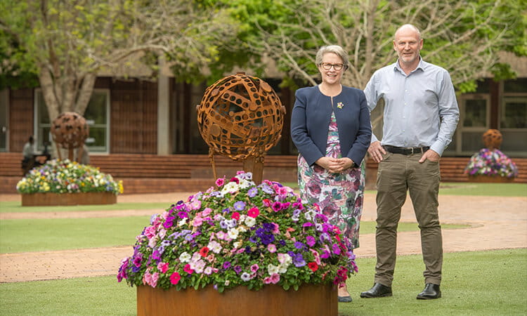 Vice-Chancellor standing with flowers in quad 