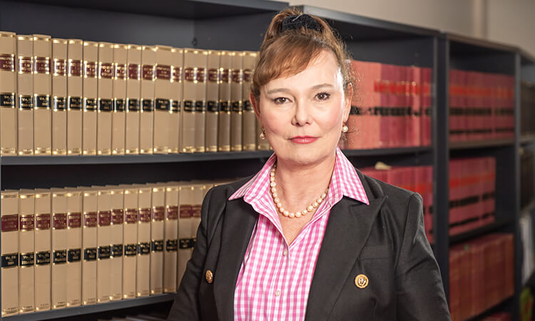 Woman standing in front of legal books.