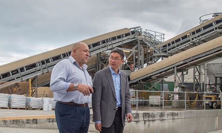 Two men standing in front of industrial factory