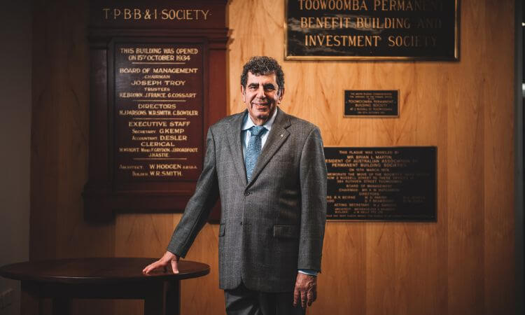 man standing in suit at table 