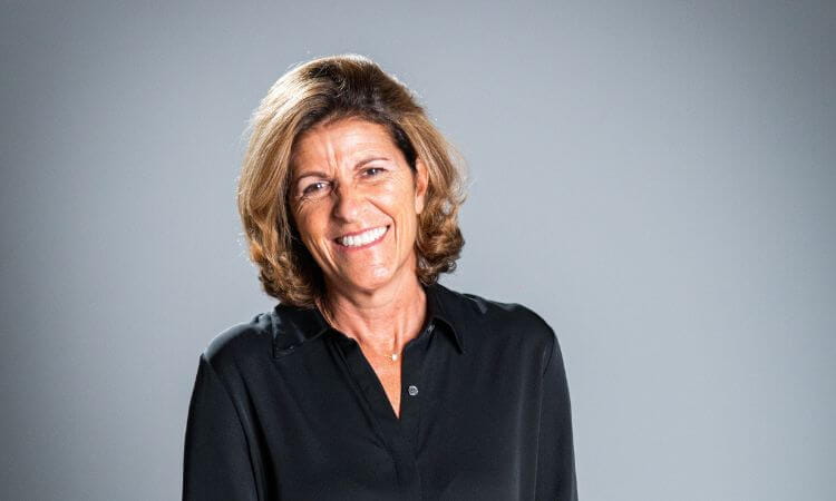 woman smiling in front of grey background 