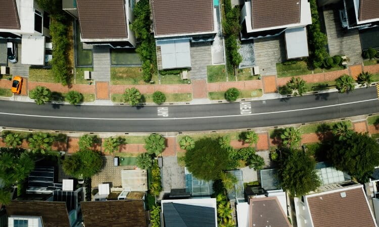 Aerial view of a suburban street lined with houses on both sides. 