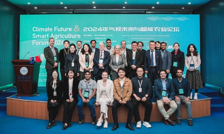 A group of people standing on a stage at the Climate Future & Smart Agriculture Forum 2024, with a presentation screen in the background.