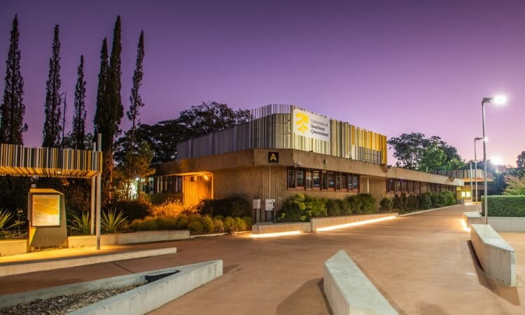 A modern building with a purple evening sky backdrop. 