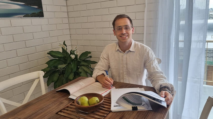 Joshua sitting at a table doing university study.